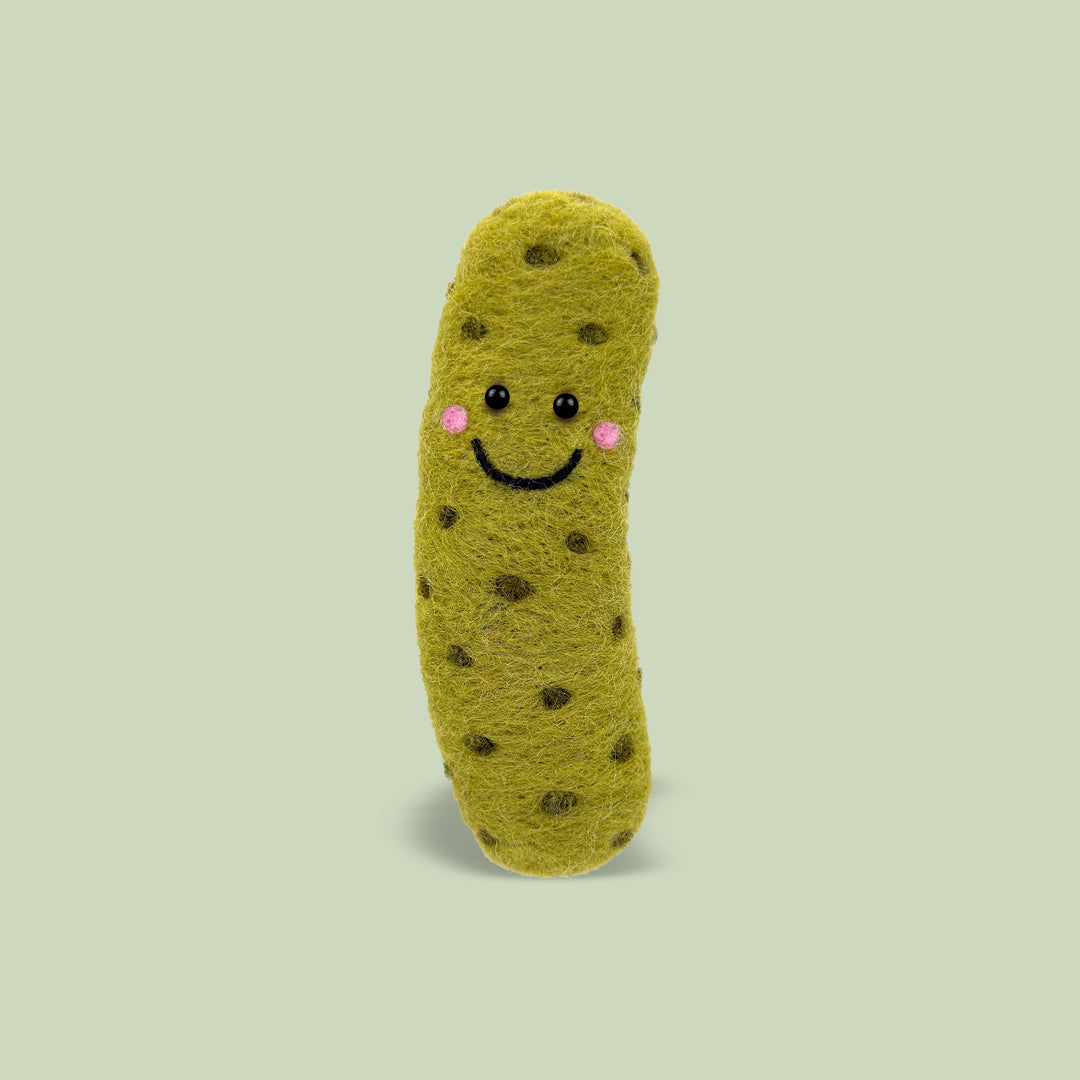 Finished Big Dill Feltie from Feltie Kits, showing a smiling felt pickle with soft green wool texture, cute facial details, and darker green pickle spots.