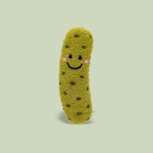 Finished Big Dill Feltie from Feltie Kits, showing a smiling felt pickle with soft green wool texture, cute facial details, and darker green pickle spots.