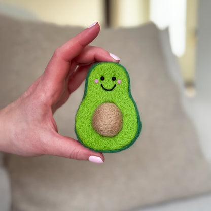 Hand holding the finished Perfect Avocado Feltie, a beginner-friendly needle-felting project from Feltie Kits