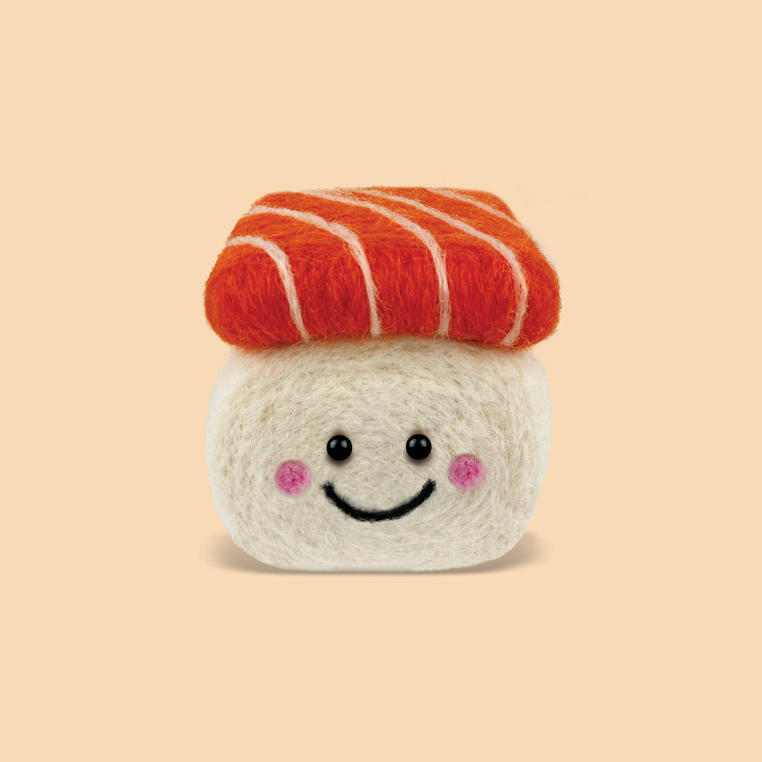 Finished Salmon Sushi Feltie made from the Feltie Kits needle felting kit, showing the smiling rice base and orange wool salmon topper.