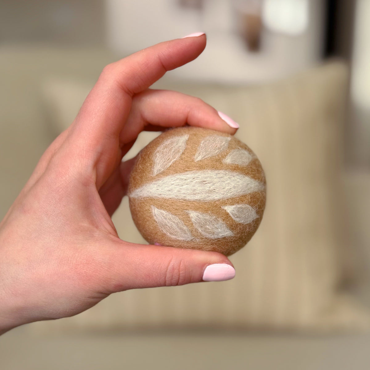 Hand holding the top of the finished Sourdough Feltie, a beginner-friendly needle-felting project from Feltie Kits