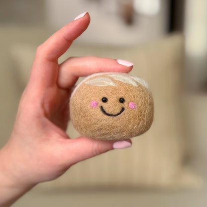 Hand holding the front of the finished Sourdough Feltie, a beginner-friendly needle-felting project from Feltie Kits