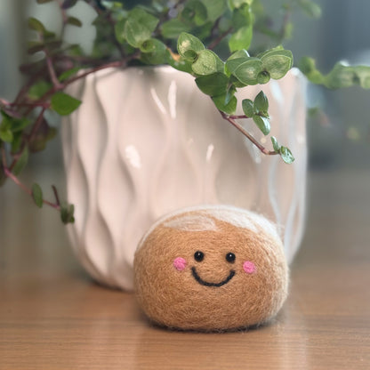Smiling handmade sourdough needle felting craft with plant in background, finished Feltie Kits DIY craft project