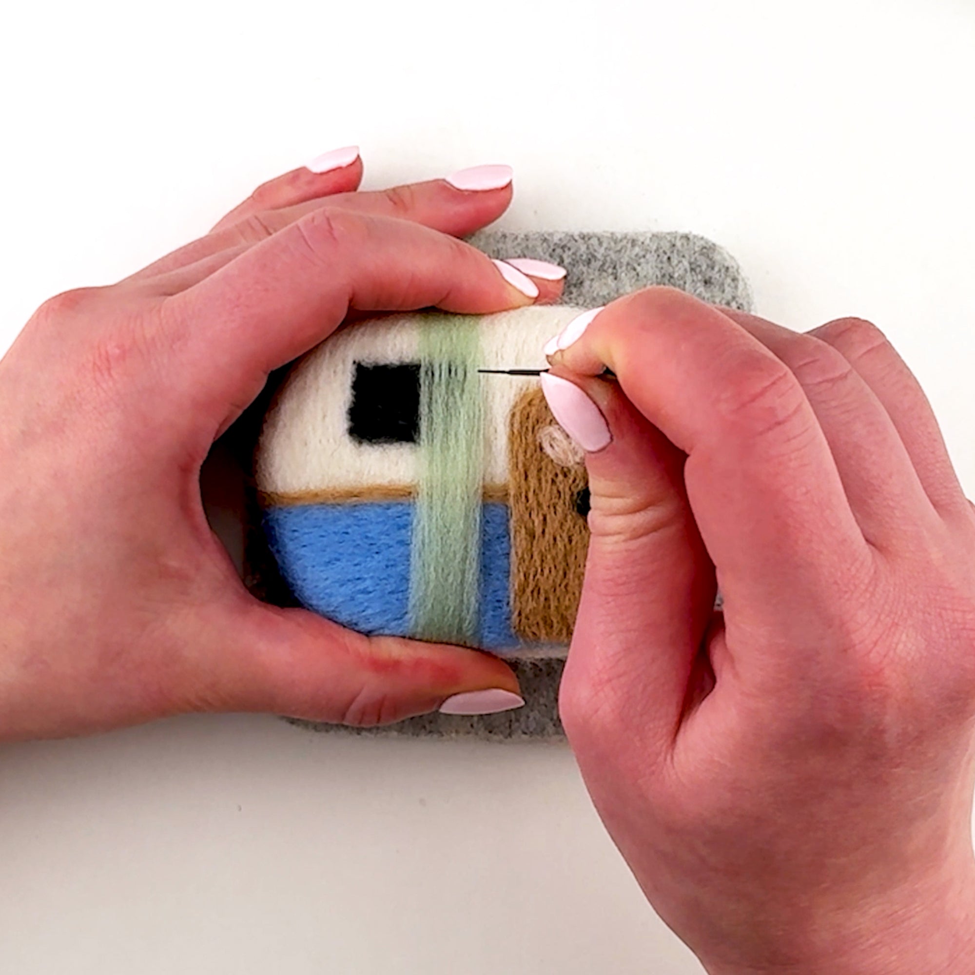 Step-by-step needle felting tutorial for The Happy Camper from Feltie Kits, showing how to add the curtains.